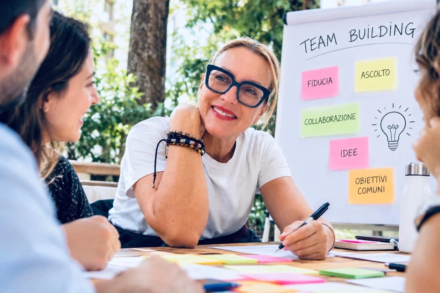 Sabrina Prioli at a table with a group, during a team-building workshop